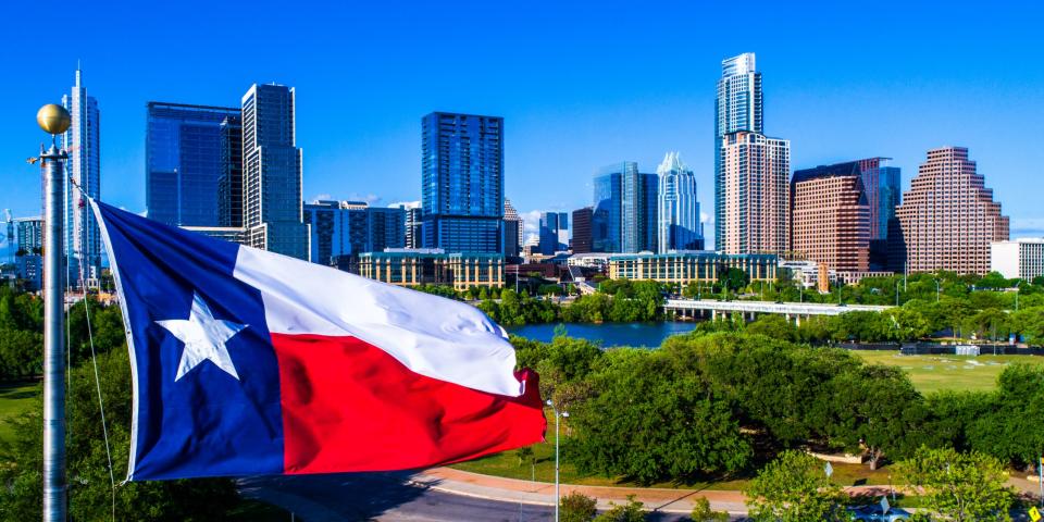 Texas flag over city skyline