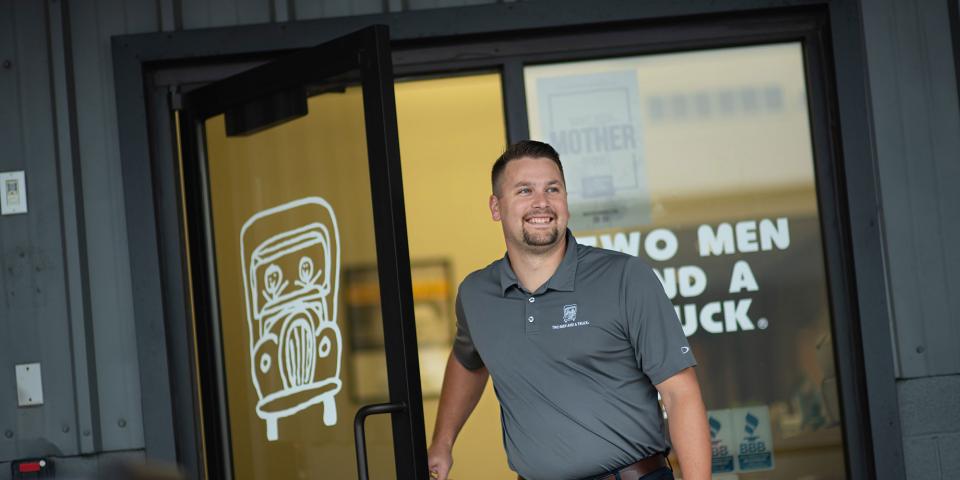 Man opening door to TWO MEN AND A TRUCK office