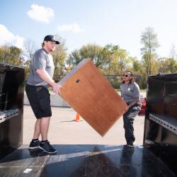 two employees placing junk into a container